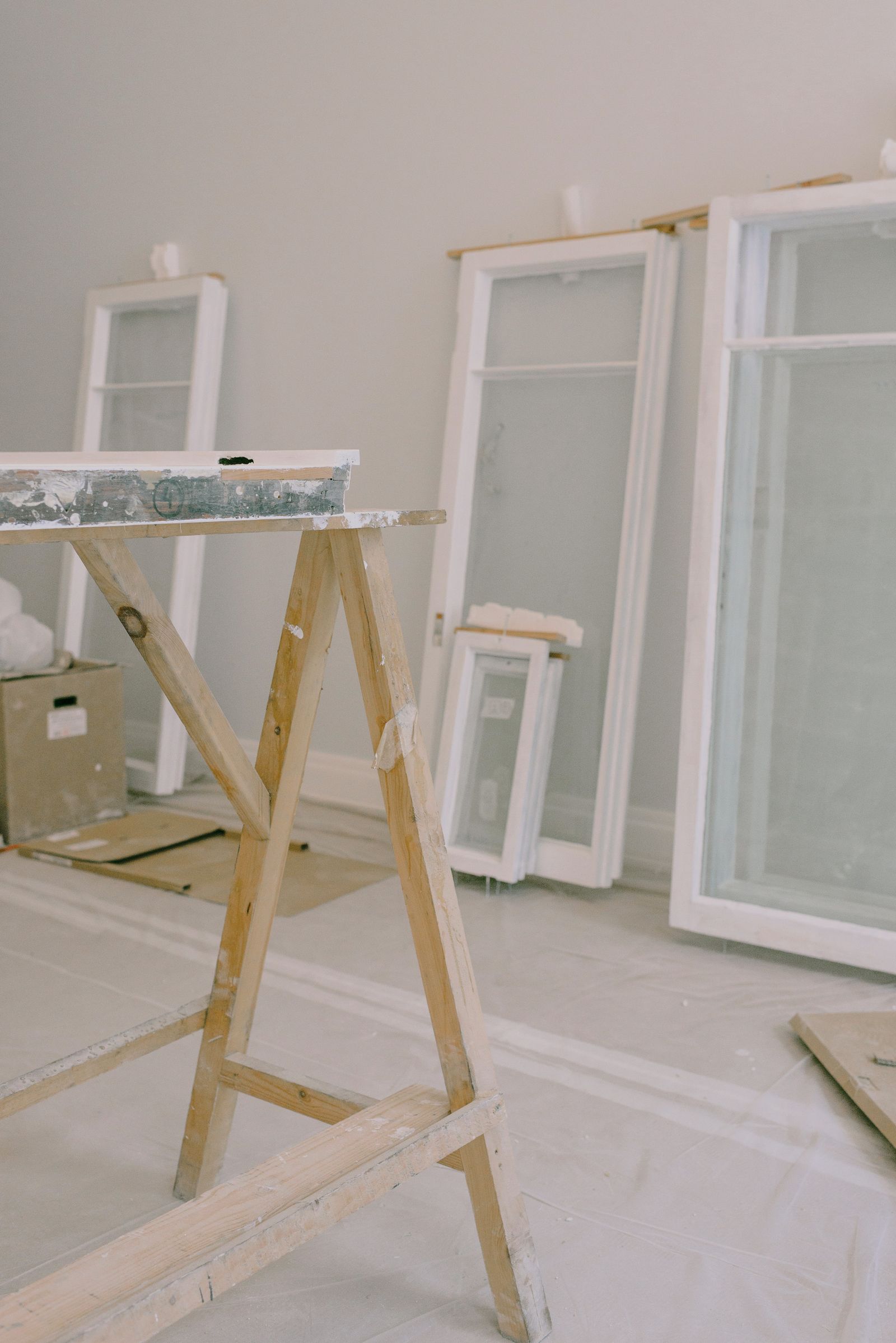 A work trestle and removed window frames in a room prepped for renovation